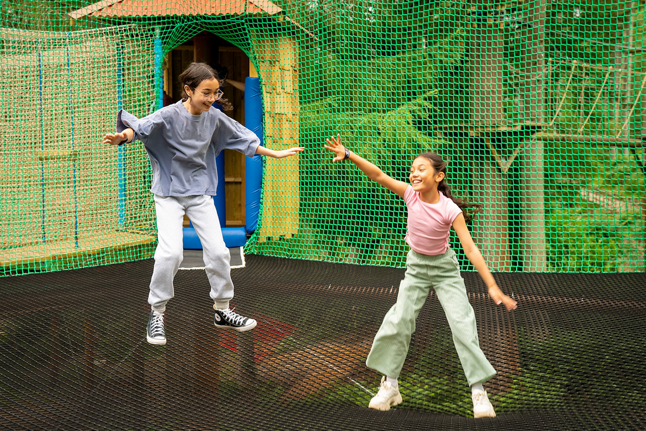 Two children jumping on the Adventure Nets activity.