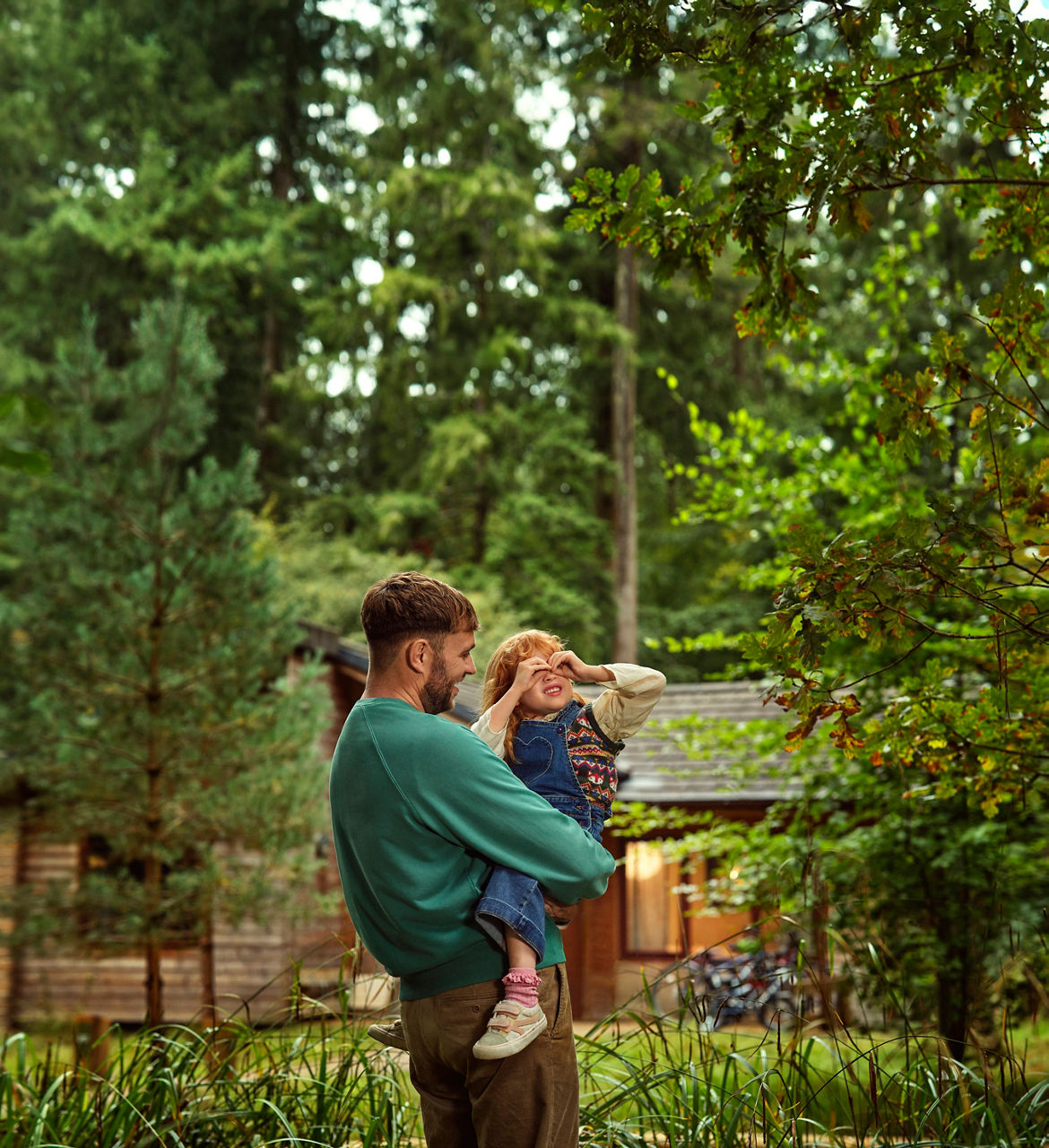 Father and daughter look at wildlife outside their lodge.