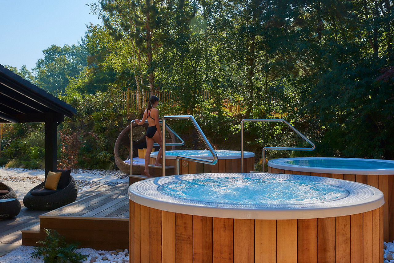 A shot of a lady stepping into a hot tub. 