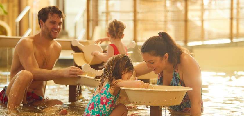 A family playing and splashing together in Venture Bay. 