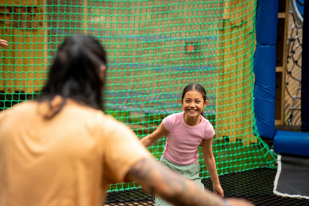 Family jumping in the Adventure Nets course suspended in the trees.