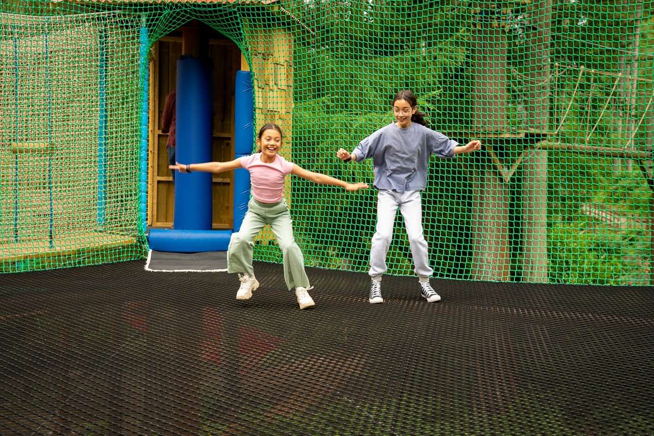 Two young people jumping on the Adventure Nets course.