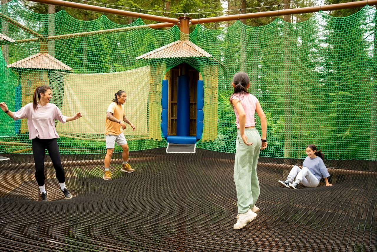 Family jumping in the Adventure Nets course suspended in the trees.