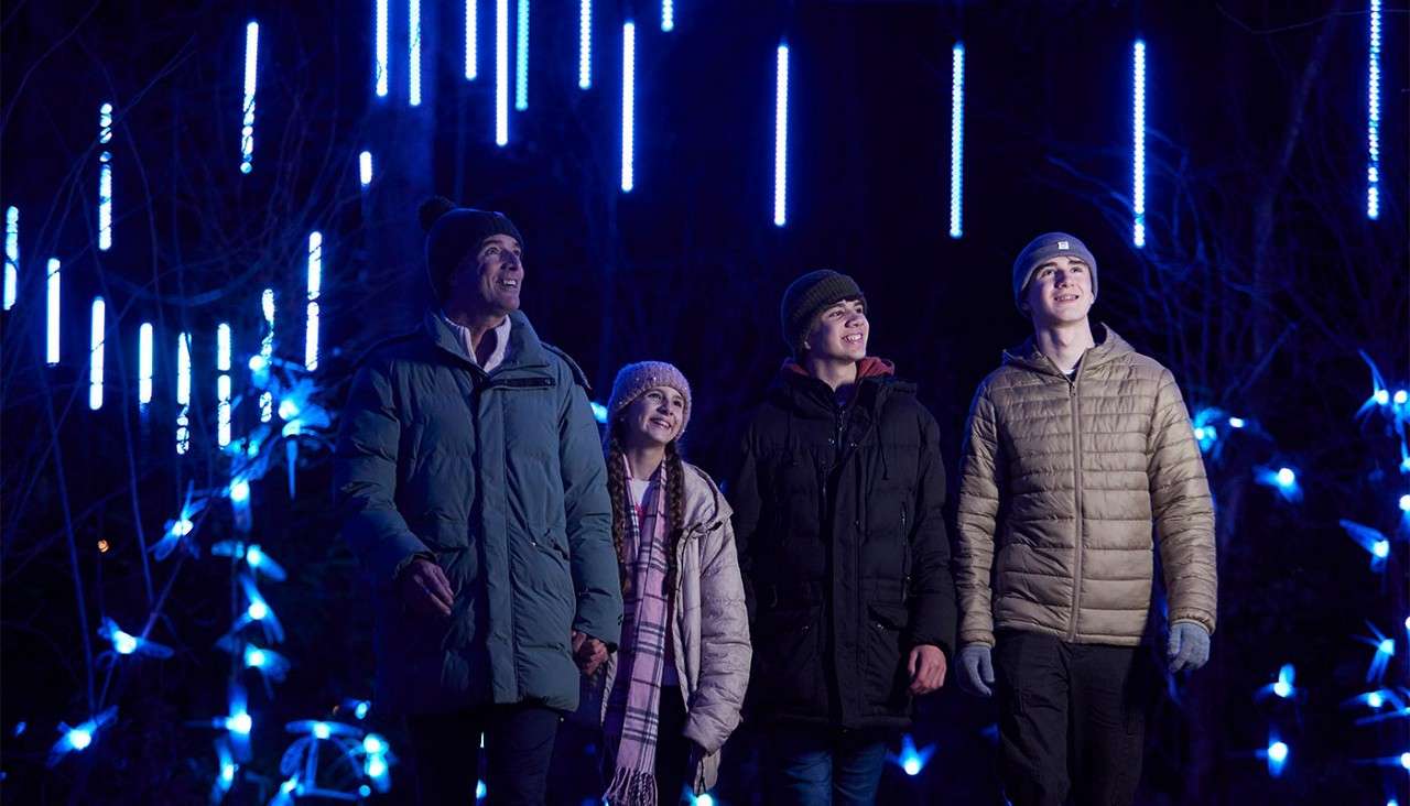 A family walking through the Enchanted Light Garden.