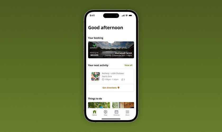 Smartphone displays a travel app dashboard, showing booking and upcoming activity, against a green gradient background. Text: Good afternoon; Your booking; Sherwood Forest; Your next activity; View all; Archery - Little Outlaws; Sports Zone; Get directions; Things to do.