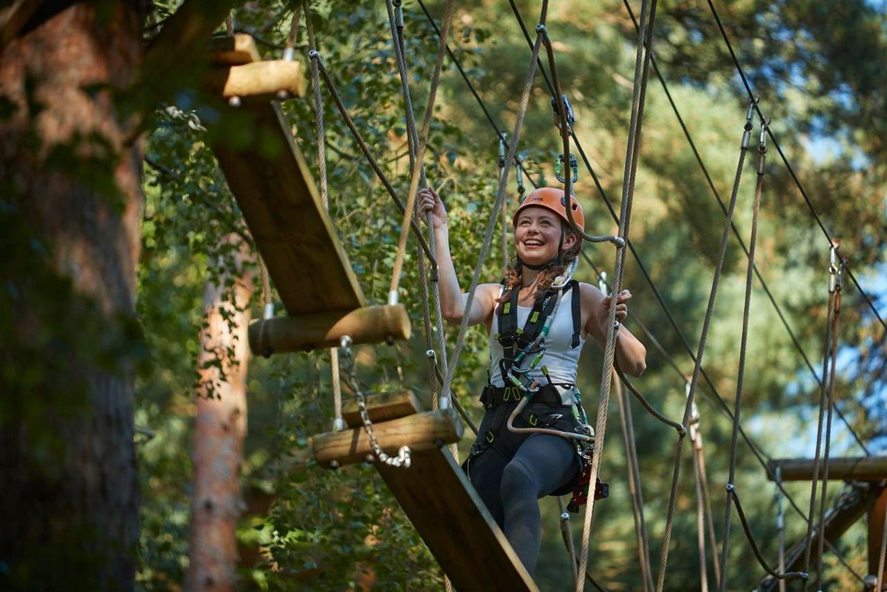 Young girl stepping onto a wobbly platform.