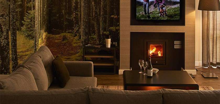 The living room of an executive lodge with sofas and a fireplace.