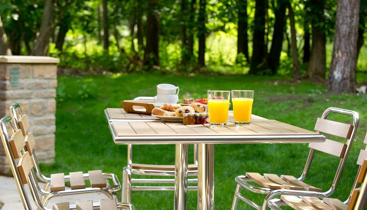 A table laid for breakfast on the patio outside of an Forest Lodge 