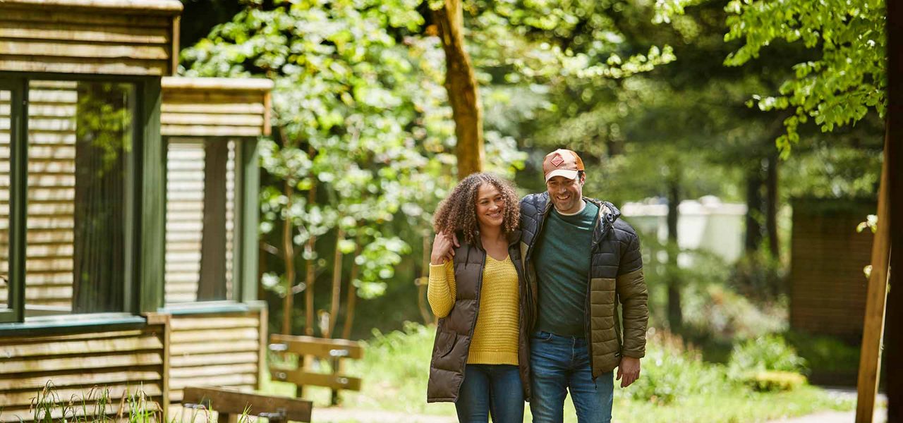 A smiling couple walking through the forest