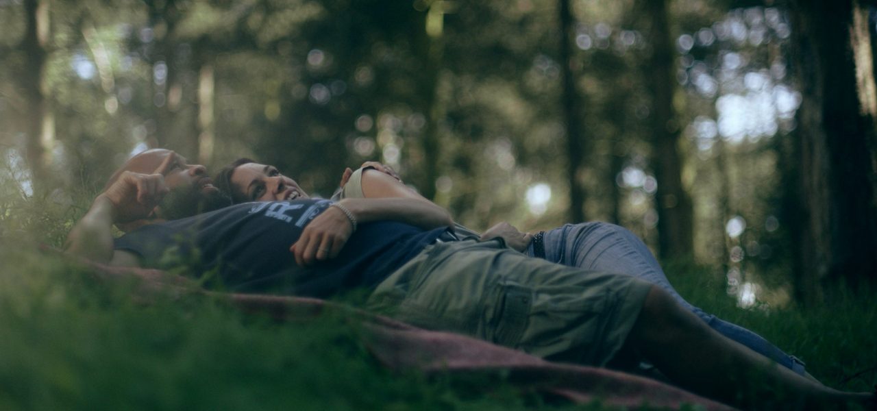 A couple lying peacefully on the forest floor