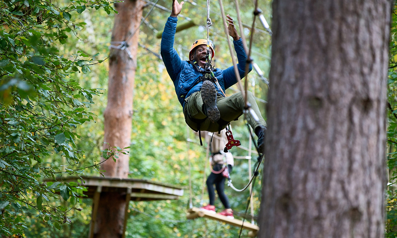 A man going down a zip wire on the Aerial Adventure.