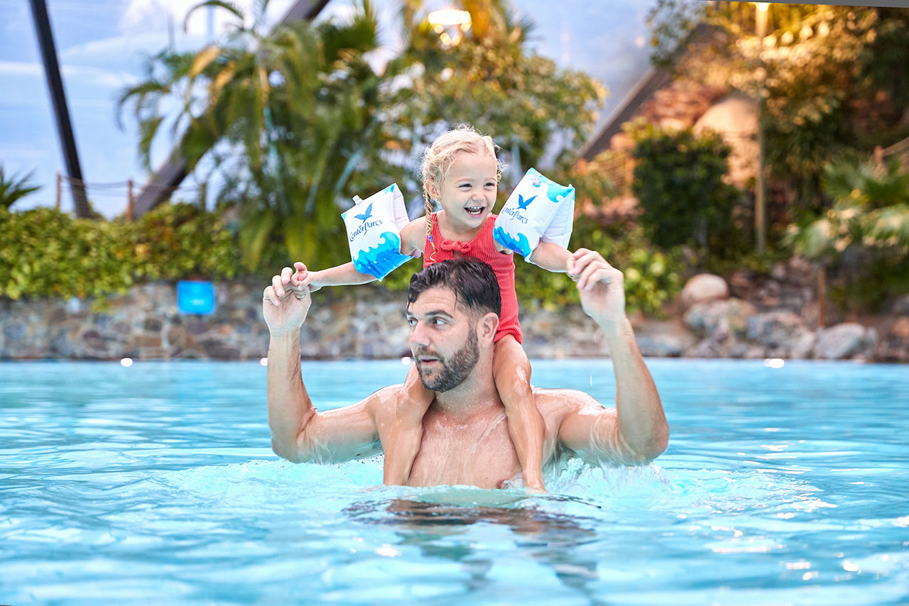 A family swimming in the indoor swimming pool.