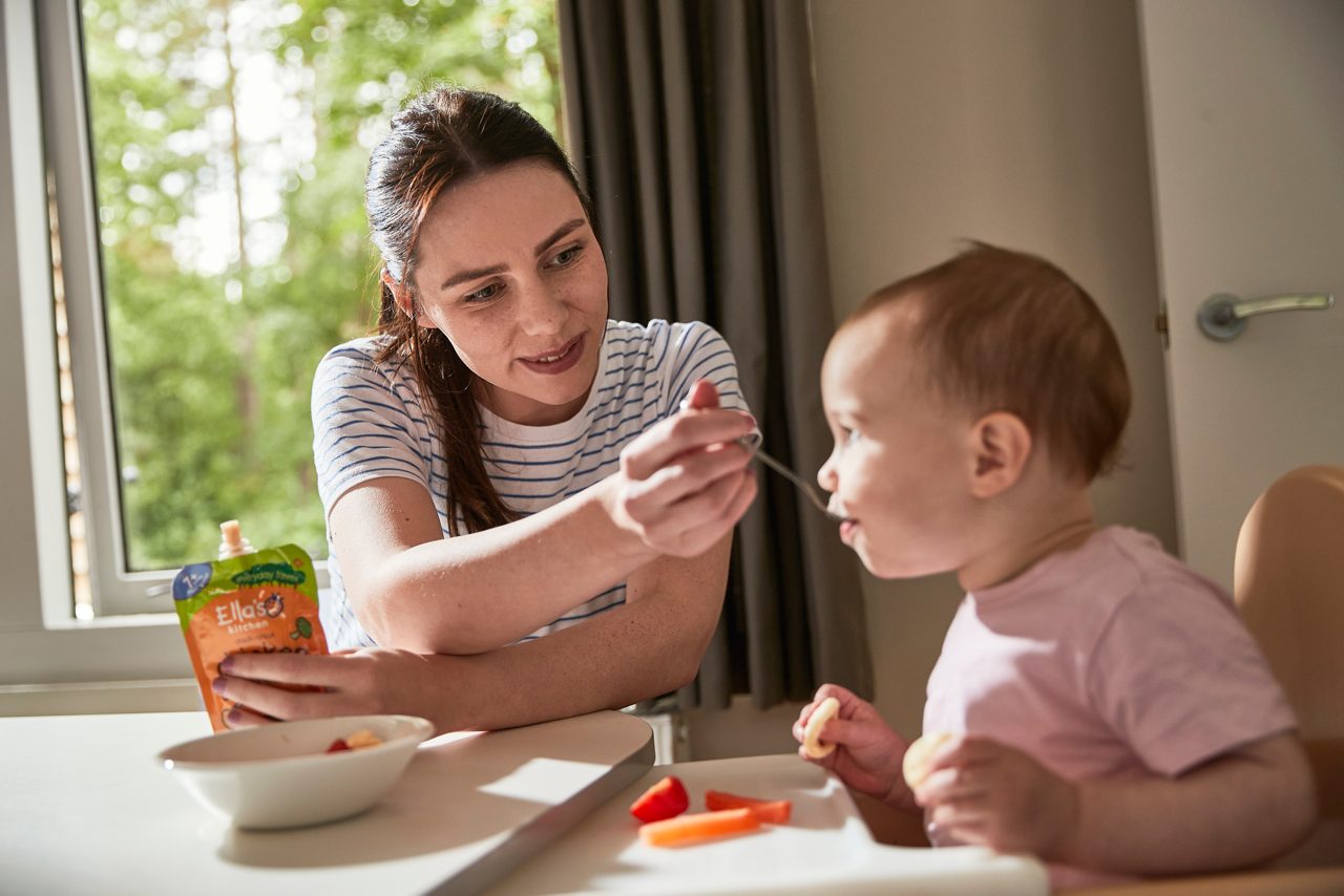 A lodge dining table with a highchair set up.