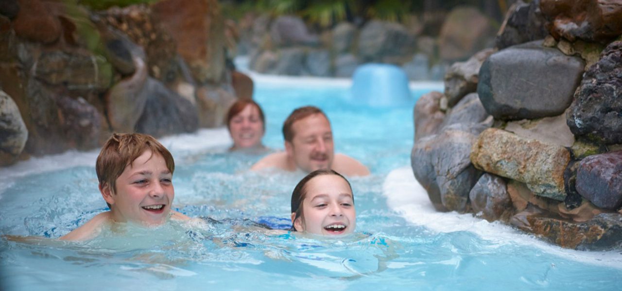A family swimming down the rapids at the Subtropical Swimming Paradise