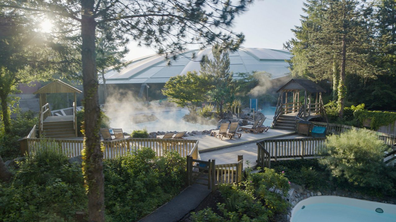 A drone shot showing the steamy outdoor pool. 
