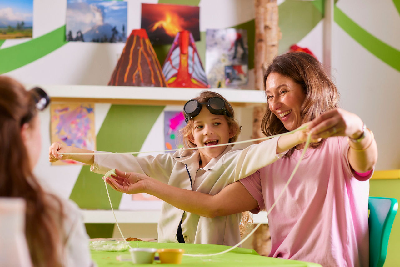 A young person taking part in Crazy Science with their mum.