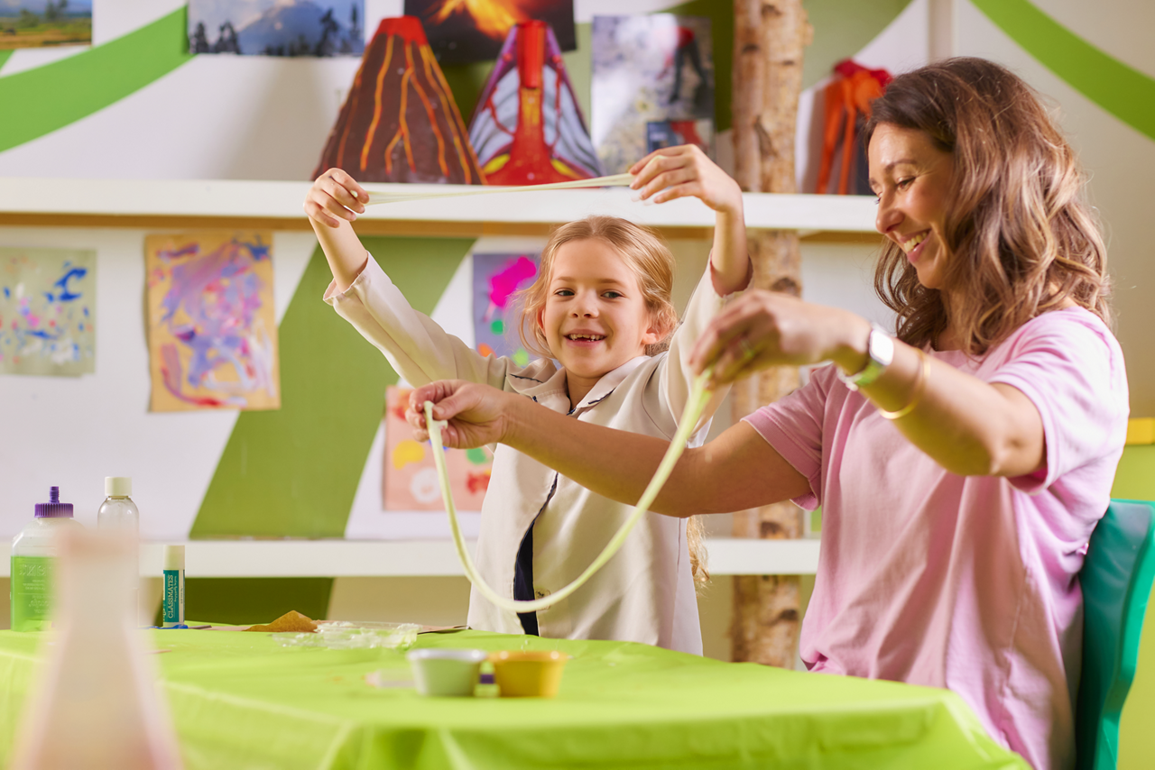 Young person accompanied by an adult whilst playing with Slime.